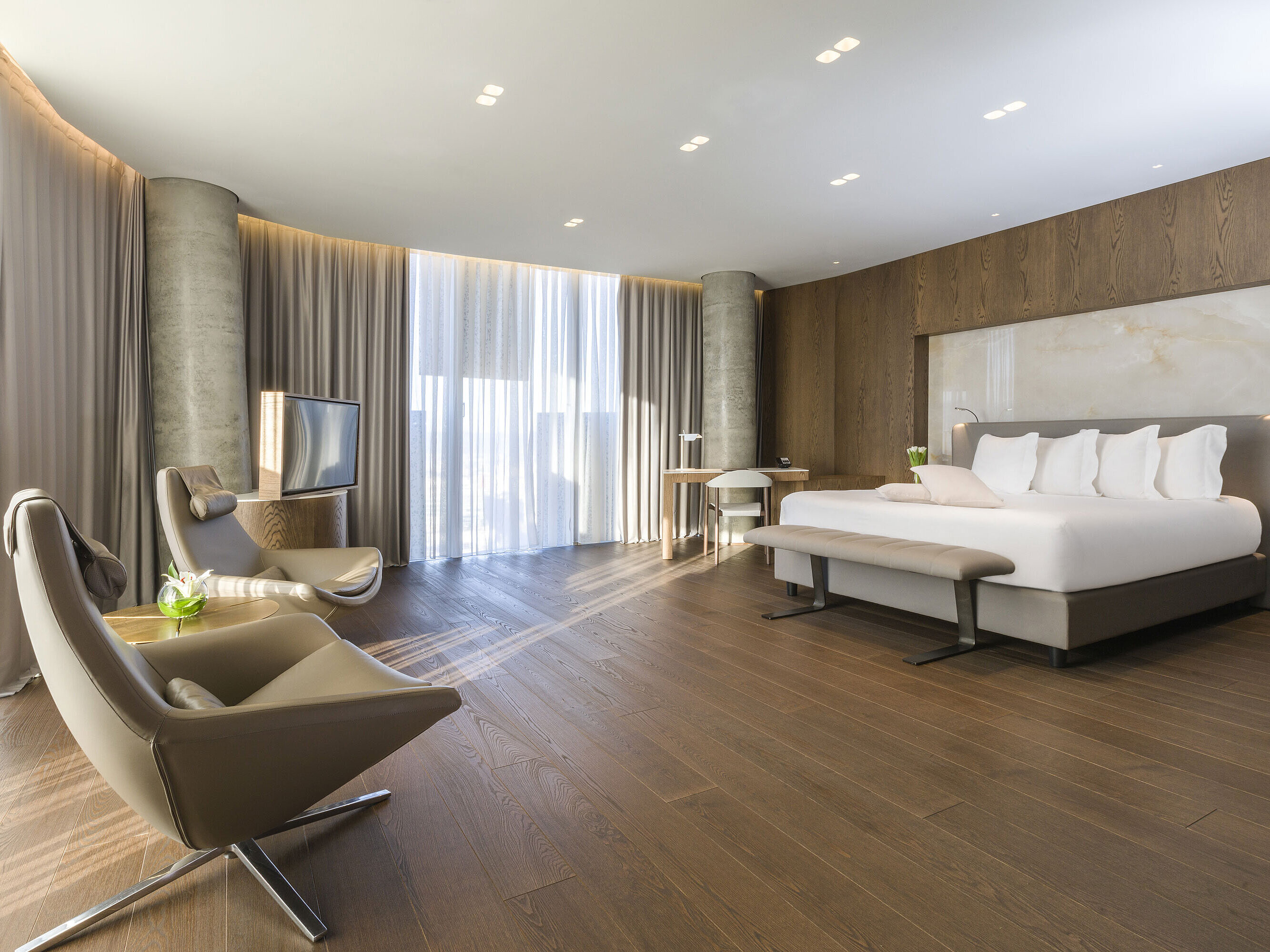 Spacious room with panoramic windows, armchairs and modern design at Maritim Hotel Plaza Tirana