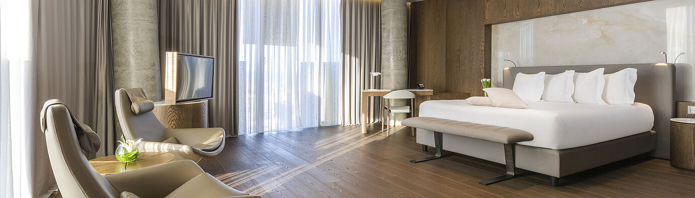Spacious room with panoramic windows, armchairs and modern design at Maritim Hotel Plaza Tirana