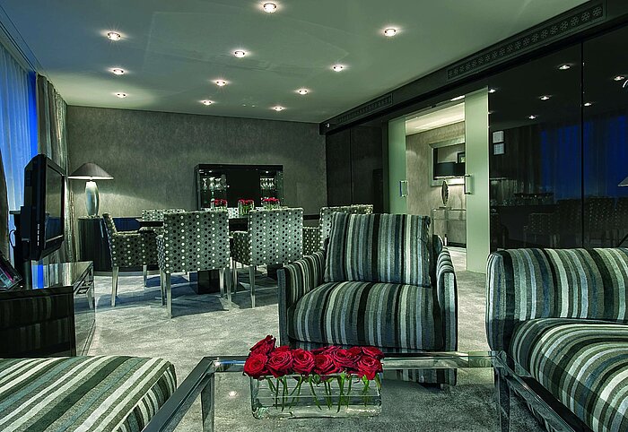 Elegant living room of the Master Suite at Maritim Hotel Düsseldorf with modern seating,stylish dining table,and cozy lighting