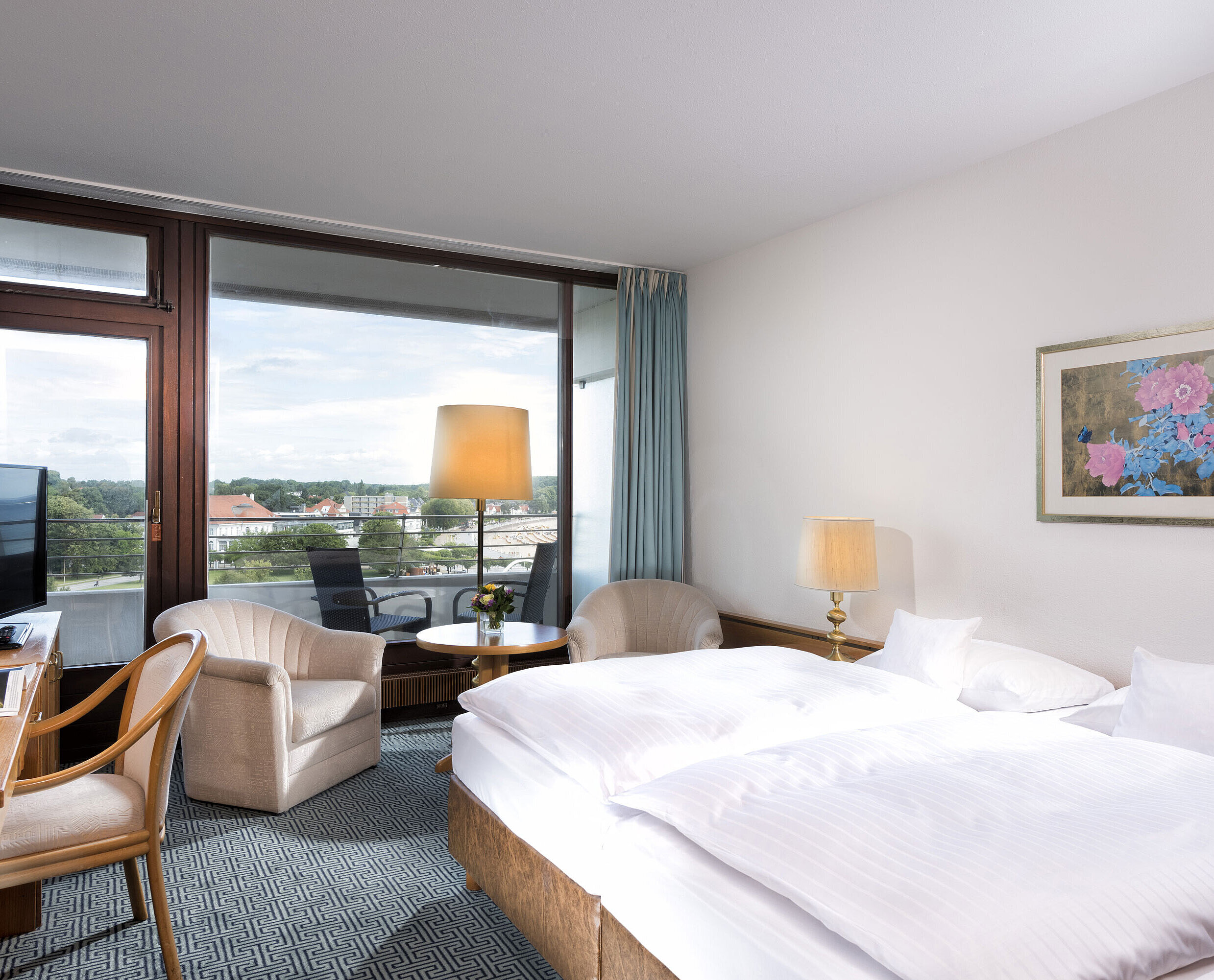 Bright double room at Maritim Hotel Travemünde with balcony and view over rooftops and water