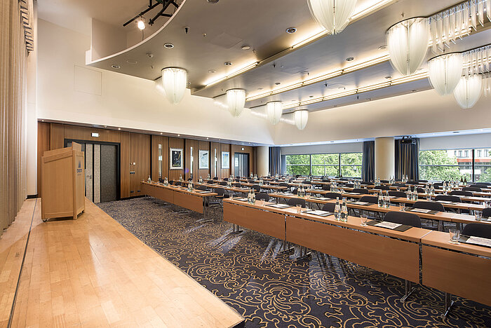  Conference room with stage and panoramic windows at Maritim Hotel Frankfurt. Row seating and modern design.