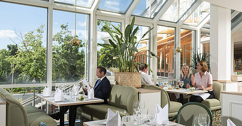 Spacious restaurant at Maritim Hotel Würzburg with panoramic windows and an inviting seating area