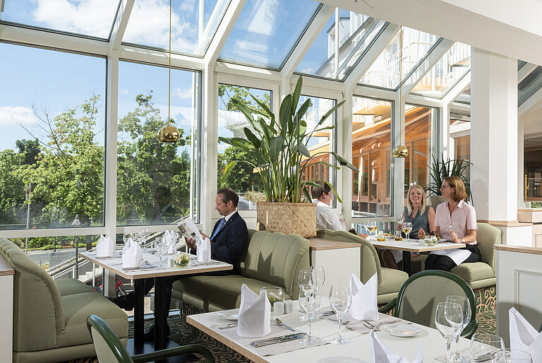 Spacious restaurant at Maritim Hotel Würzburg with panoramic windows and an inviting seating area