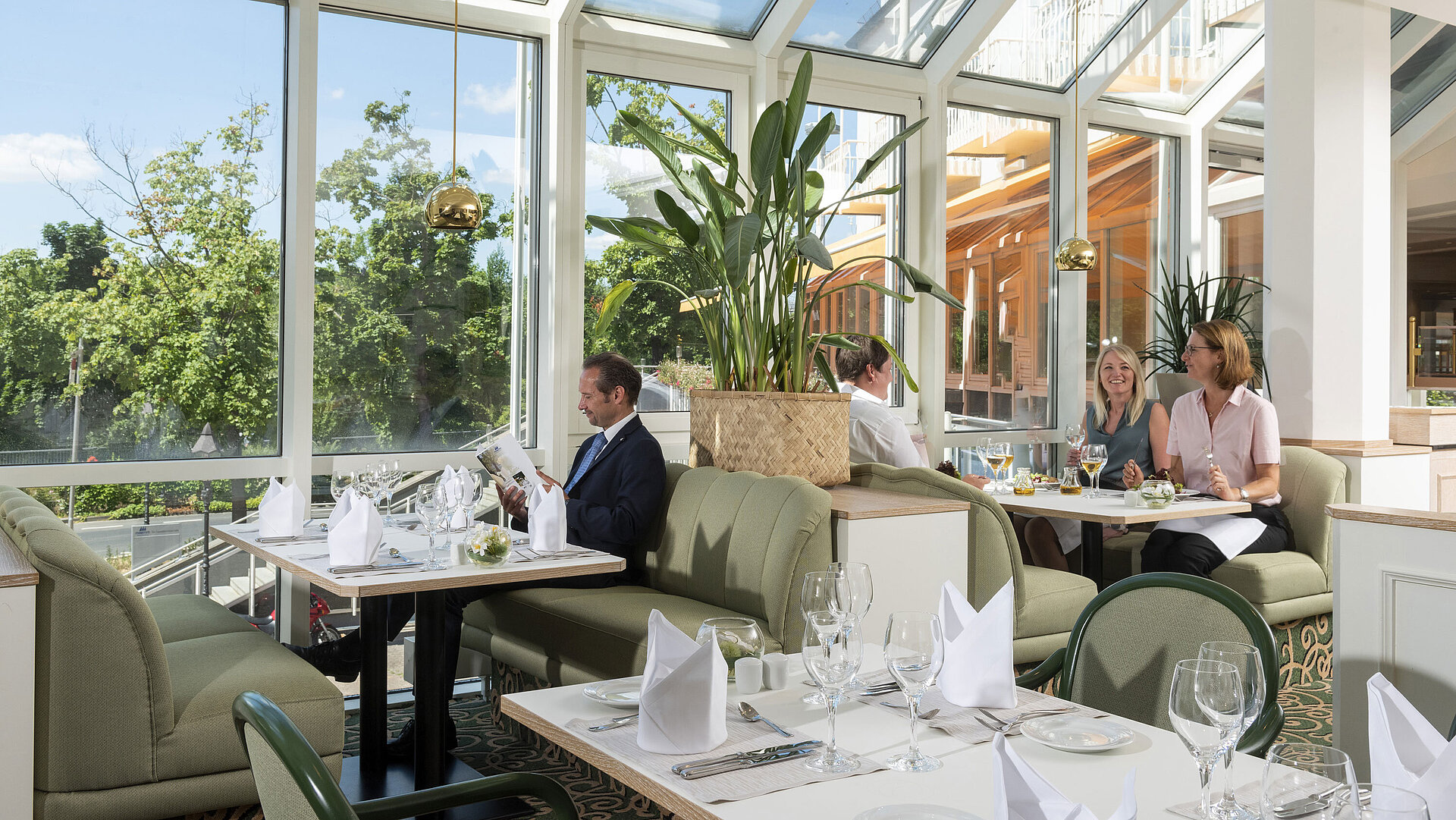 Spacious restaurant at Maritim Hotel Würzburg with panoramic windows and an inviting seating area