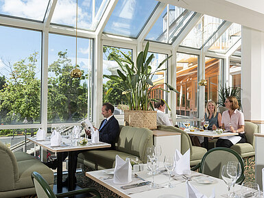 Spacious restaurant at Maritim Hotel Würzburg with panoramic windows and an inviting seating area