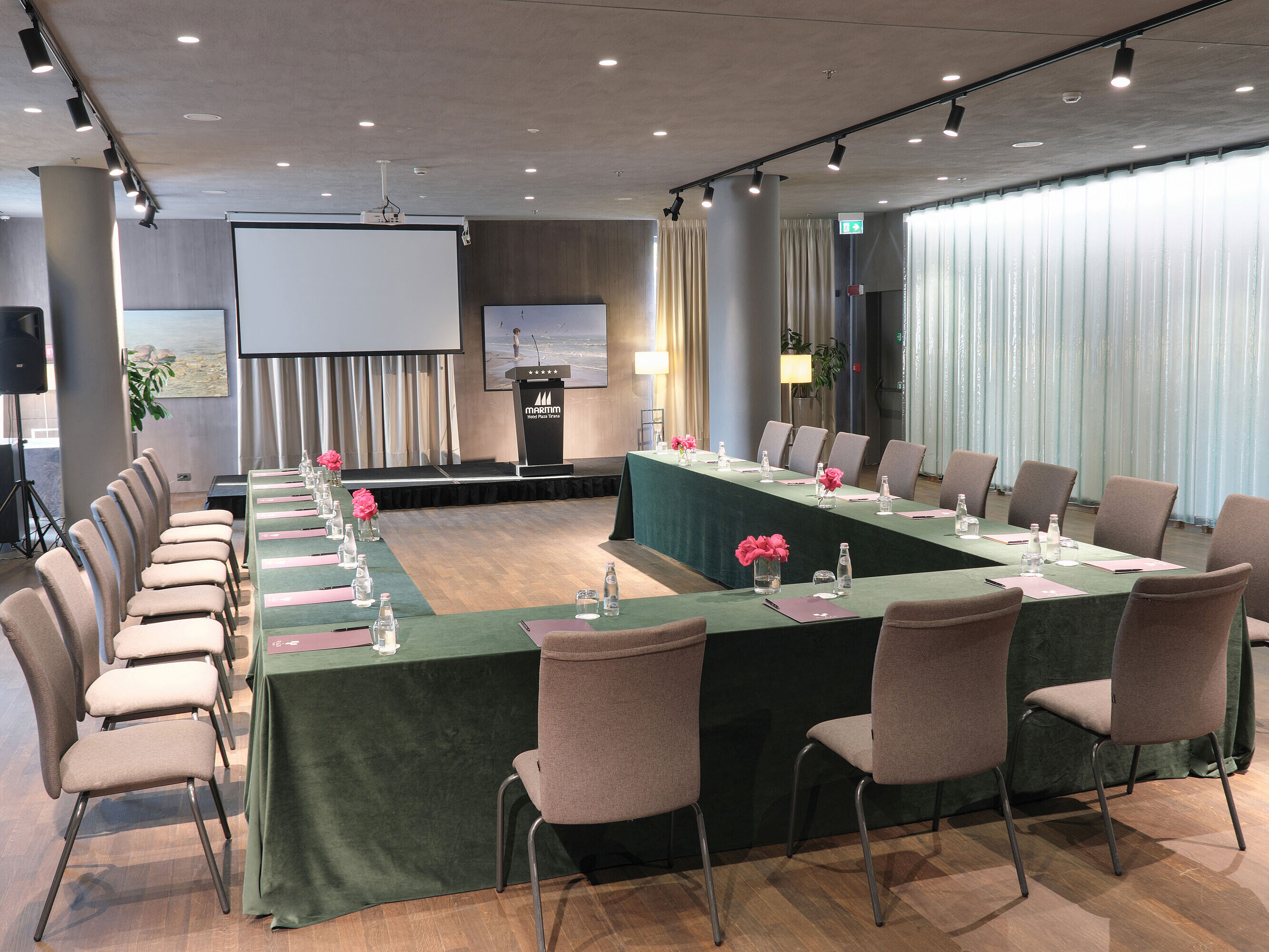 Stylish space at Maritim Hotel Plaza Tirana with U-shape seating, screen and fresh flowers