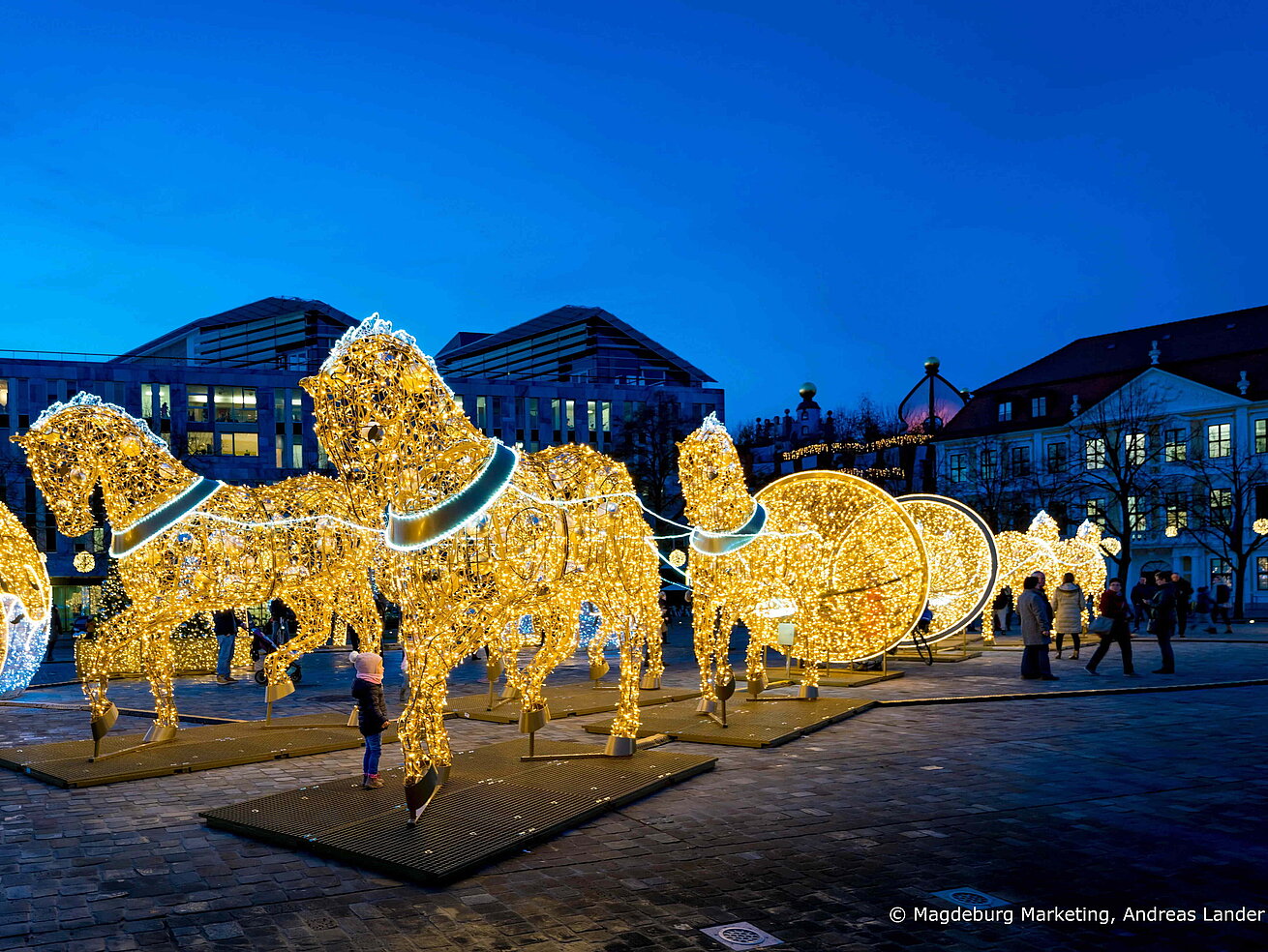 Festive illuminated figures and light installations at Magdeburg Light World at dusk.