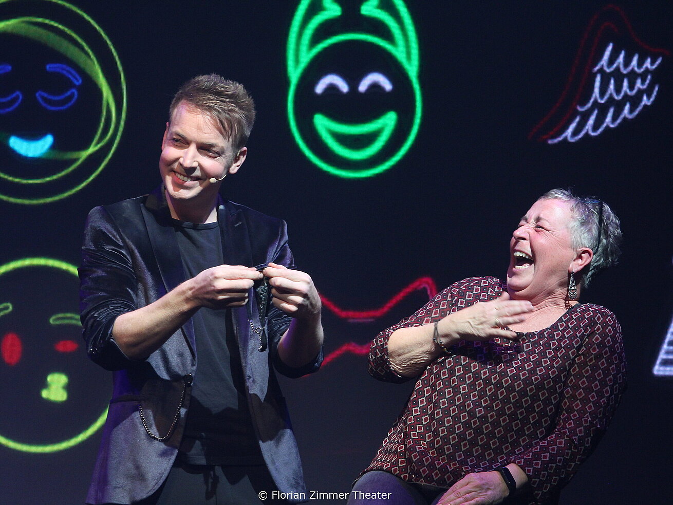 Magician Florian Zimmer performing on stage at Theatre Ulm with lighting effects.