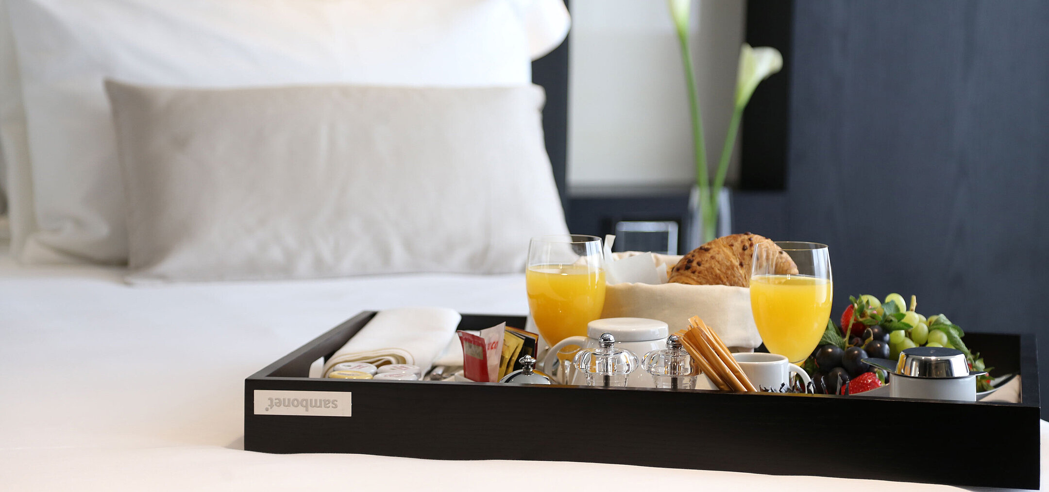 Breakfast tray with juice, pastries and fruit placed on the bed at Maritim Hotel Plaza Tirana