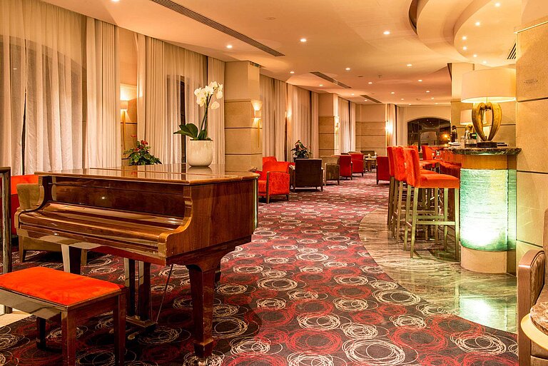 Elegant hotel bar with piano, bar stools and a cosy lounge atmosphere