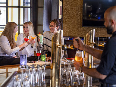 Guests enjoying cocktails at the bar of the Maritim Hotel Würzburg.