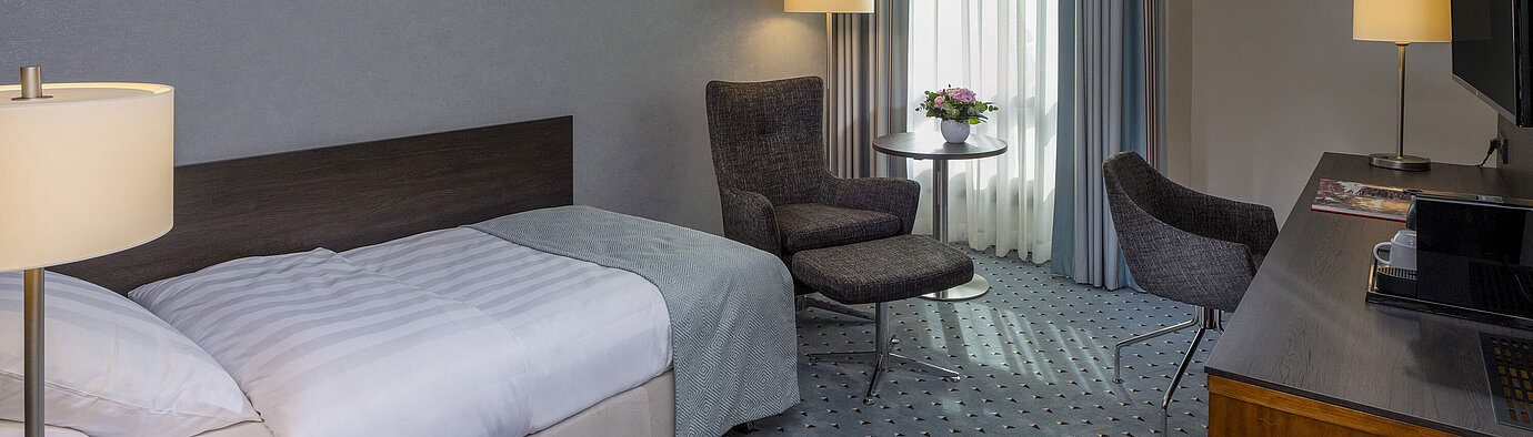 Comfortable Superior single room at Maritim Hotel Bremen with desk, armchair, and modern design.
