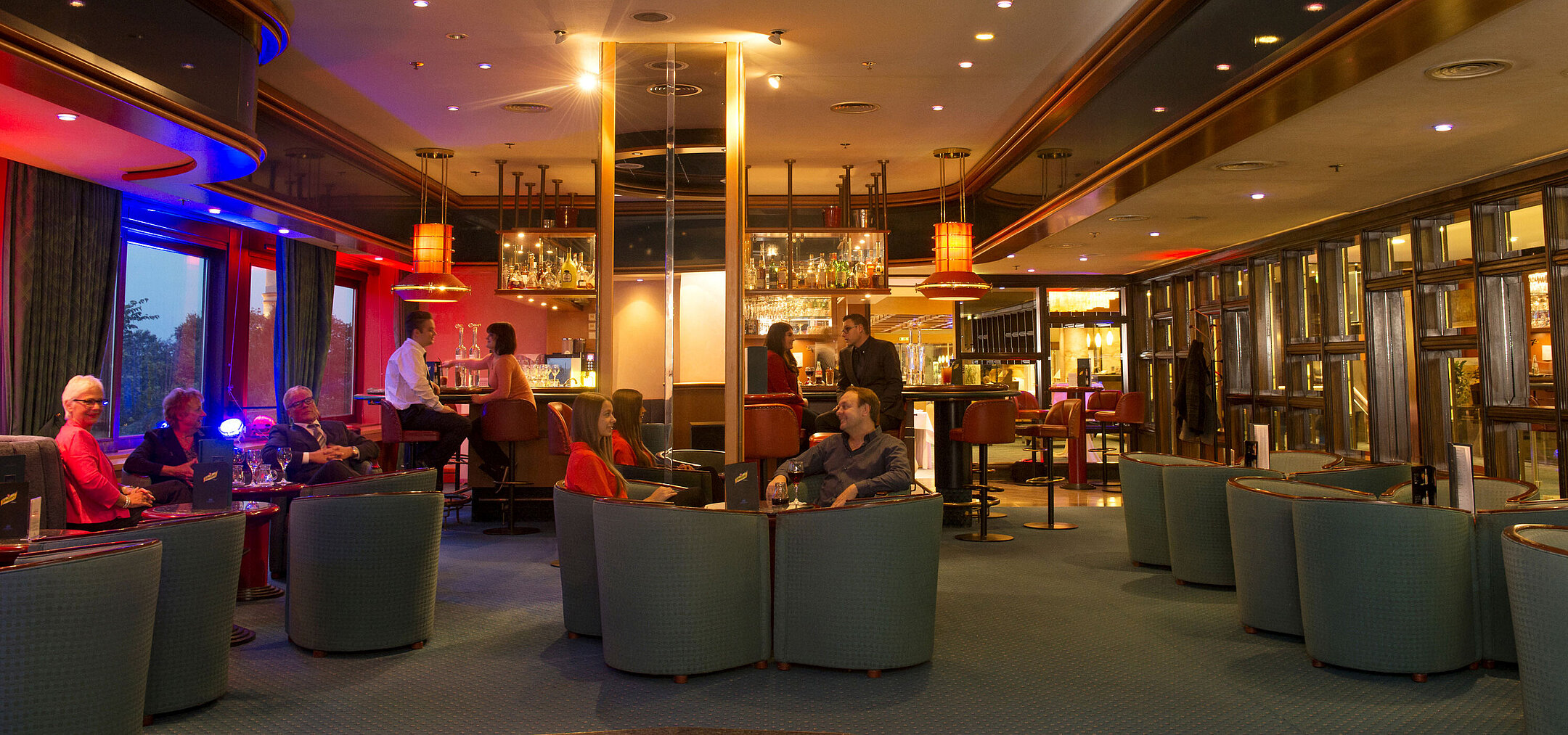 Guests enjoy drinks and chats in the stylish bar of Maritim Hotel Travemünde in the evening