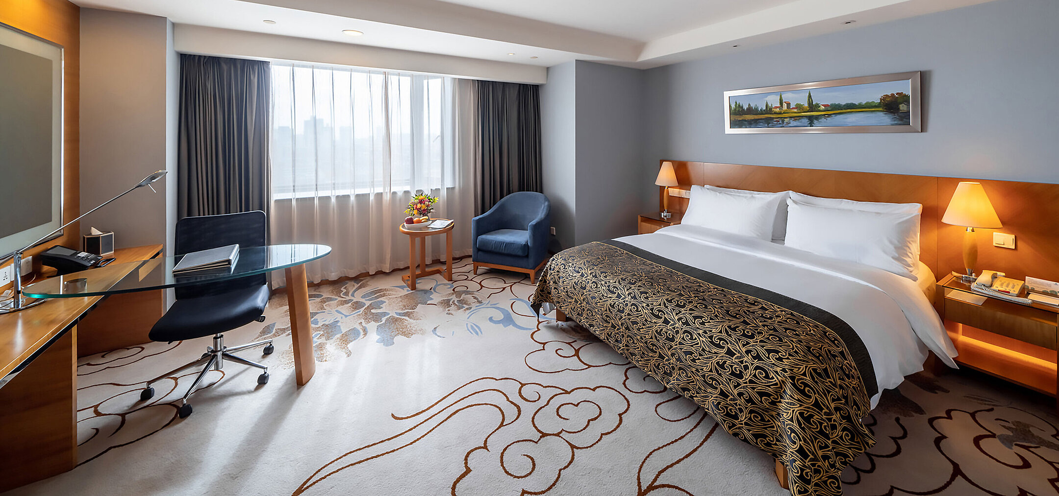 寬敞的酒店客房配備特大床、現代化工作區、藍色扶手椅及大面積落地窗，採光充足