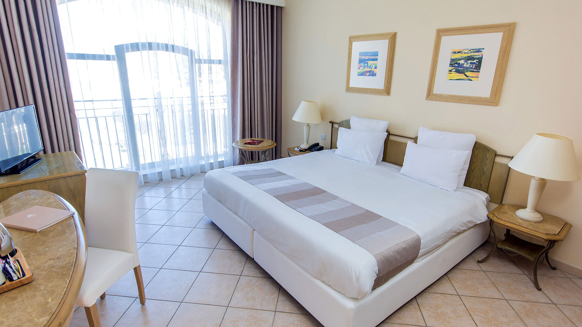 Modern double room with large window, twin beds, desk and bright living atmosphere