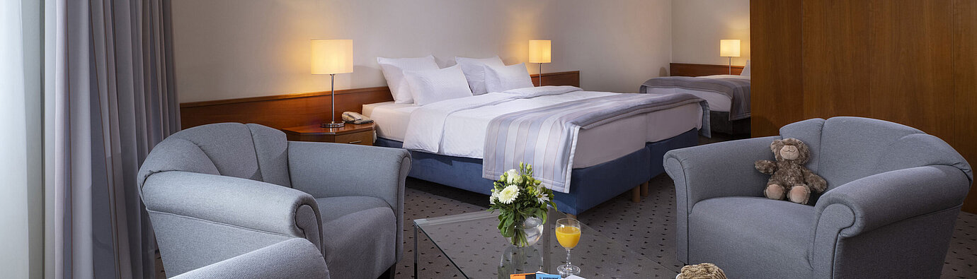 Family room at Maritim Hotel Hannover with double bed, single bed, seating area and lovely details.