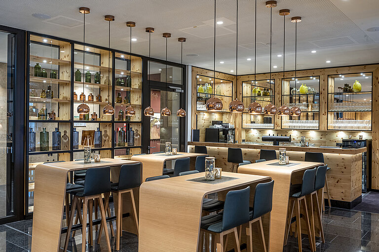 Elegant bar with wooden decor, stylish pendant lights, and high seating at Maritim Hotel Ingolstadt.