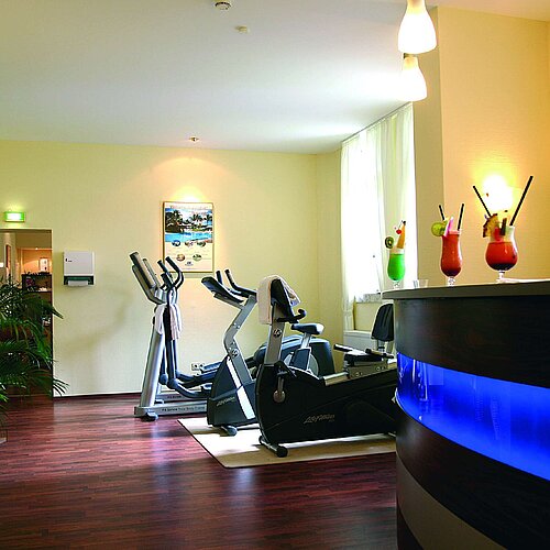 Bright fitness room at Maritim Hotel Bad Wildungen with drinks counter and cardio equipment