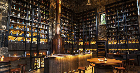 Stylish bar with copper still, extensive spirits selection and natural stone walls