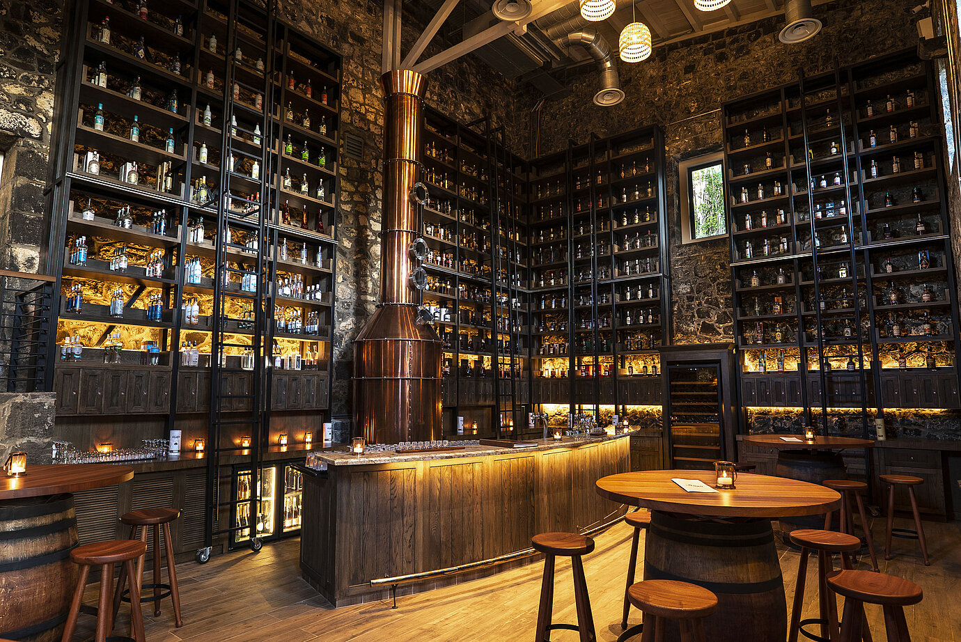 Stylish bar with copper still, extensive spirits selection and natural stone walls
