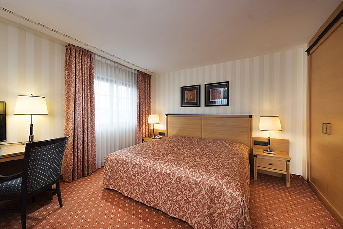 Junior Suite at Maritim Hotel Dresden with spacious bed, desk, and elegant decor.