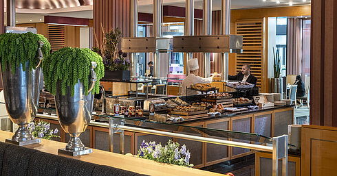 Live cooking station in the breakfast area of Maritim Hotel Düsseldorf with fresh baked goods and elegant decor.