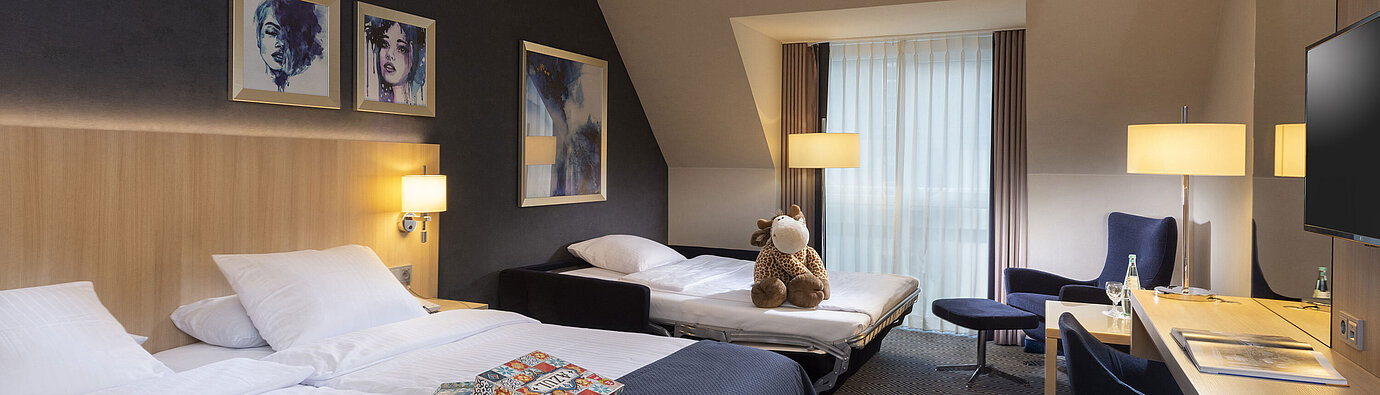 Comfort family room at Maritim Hotel Würzburg with sofa bed, double bed and plush toy