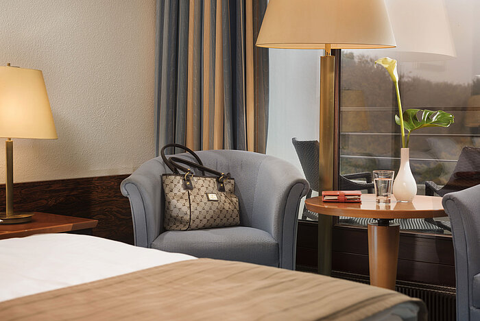 Classic room at the Maritim Hotel Kiel with a cozy seating area, table lamp and stylish decor, ideal for relaxing moments.