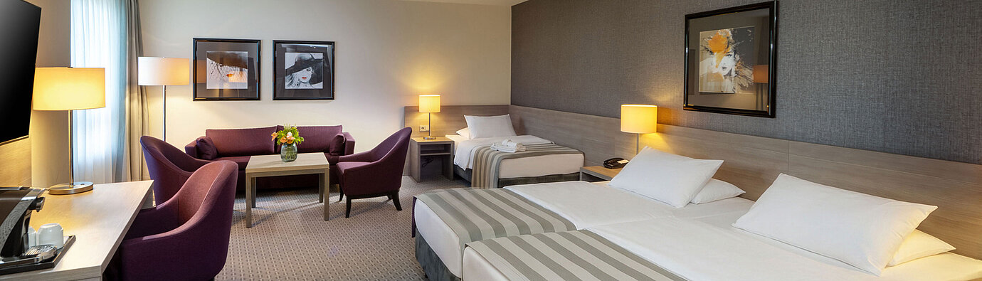 Classic Family Room at Maritim Hotel Königswinter with a double bed, sofa bed and cosy seating area.