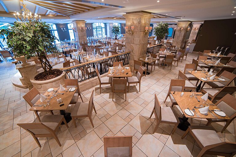 Elegant restaurant area with set tables, columns and bright interior design