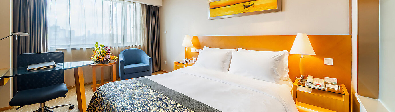 現代化酒店客房配備寬敞床鋪、書桌、舒適休憩區及充足自然光線，營造舒適放鬆的氛圍