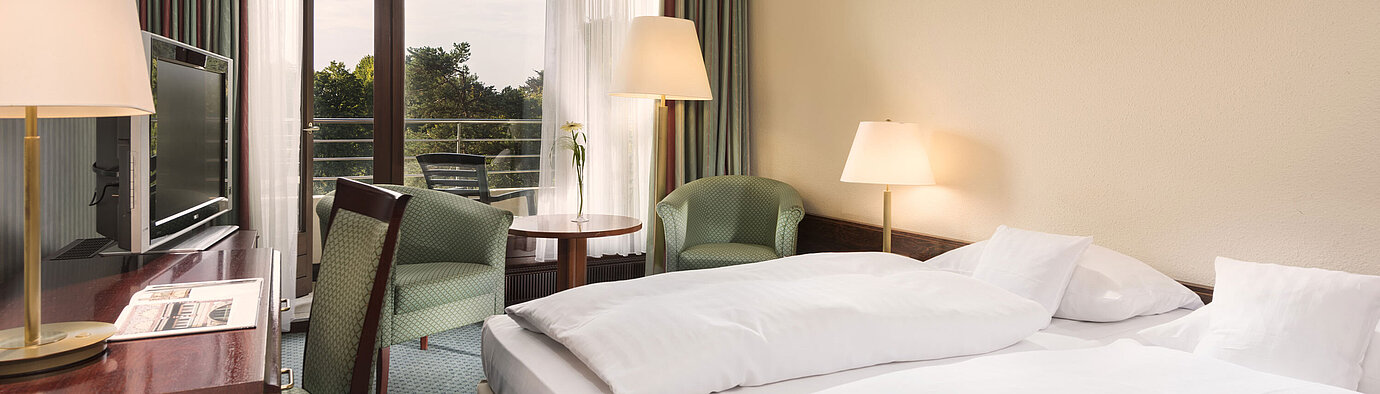 Double room with balcony, armchairs and desk at Maritim Hotel Bad Salzuflen