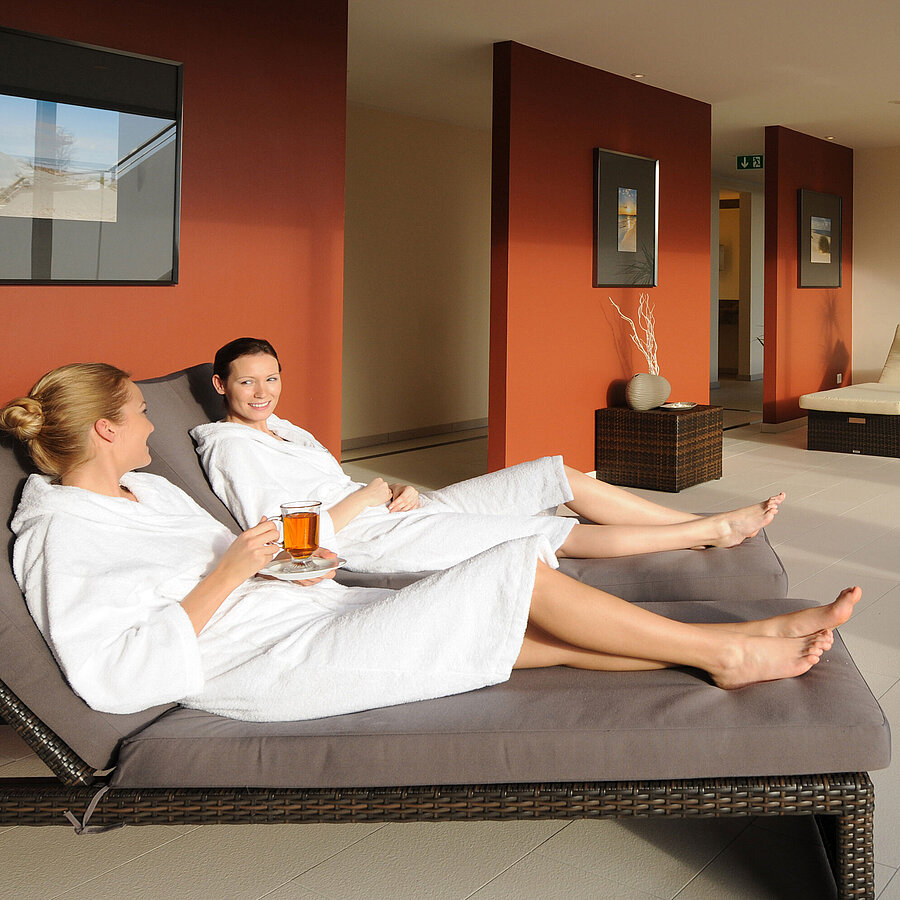 Two women relax with tea in the spa area of the Maritim Hotel Travemünde.