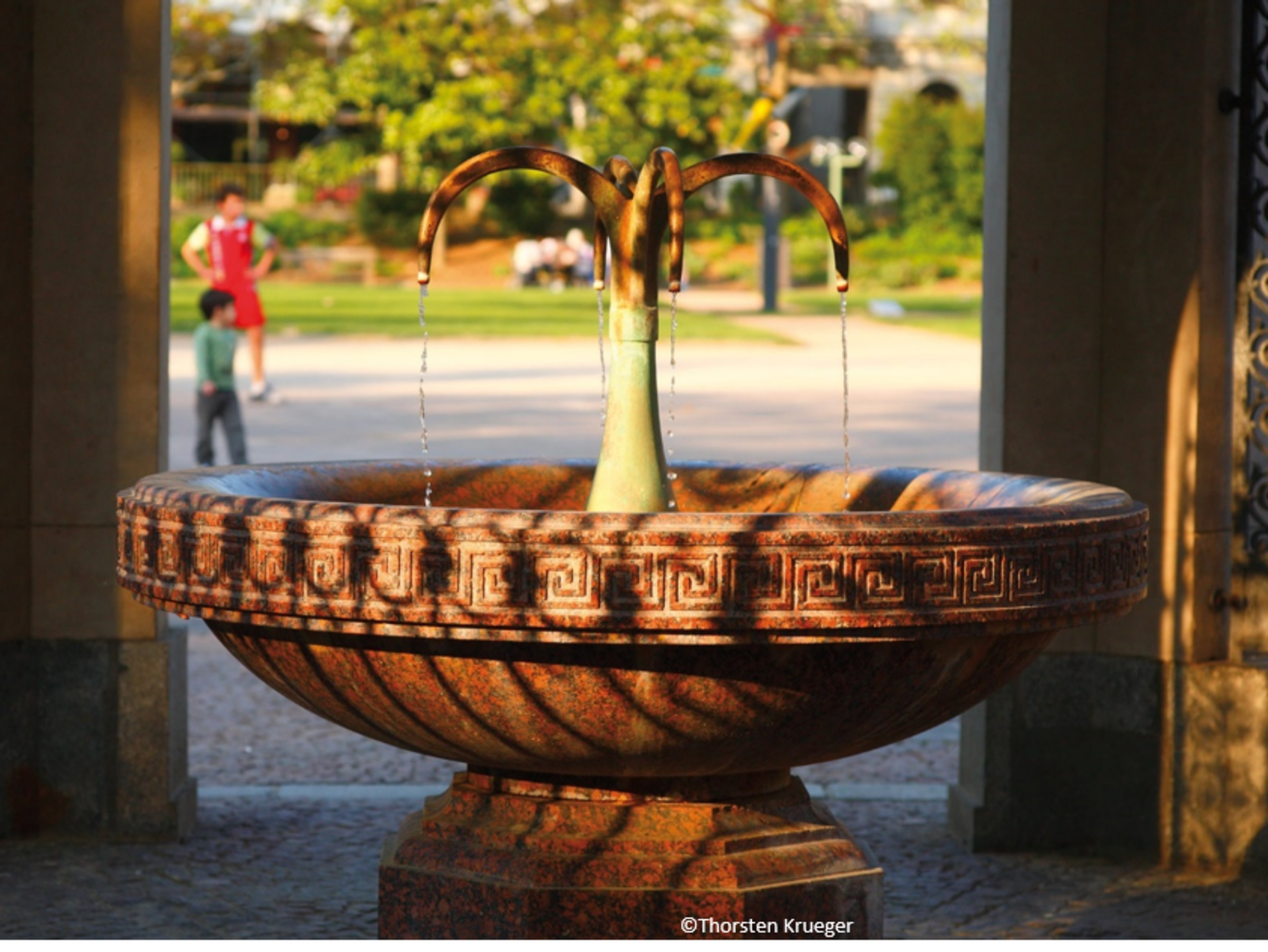 Historic stone fountain with flowing water in a park
