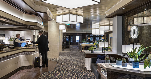 Reception at Maritim Hotel Darmstadt with modern design, friendly staff, and elegant decor.