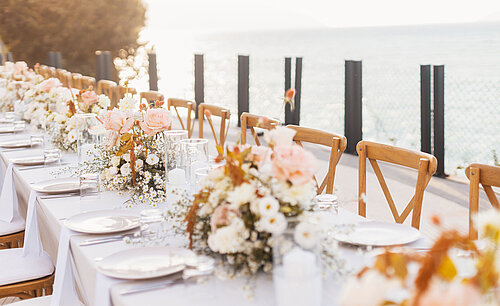 Romantic outdoor dining table by the water at Maritim Resort Marina Bay with floral décor