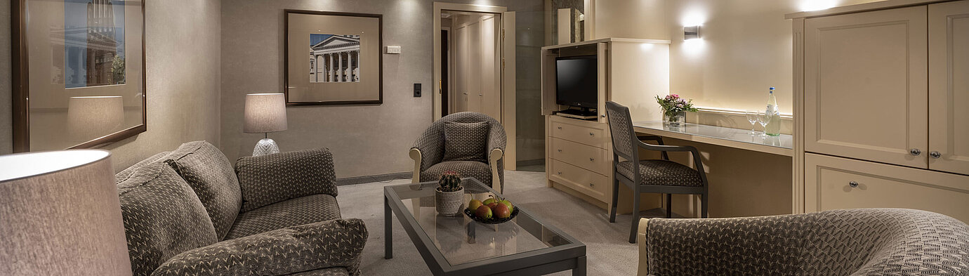 Elegant suite at Maritim Hotel Darmstadt with cozy seating area, stylish lighting, and desk for business or leisure stays.