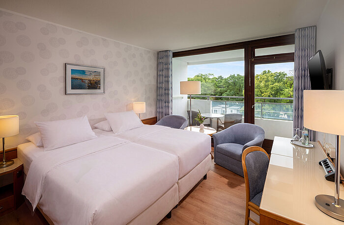 Classic Room with double bed, seating area, desk and large window overlooking the greenery