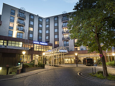 Atmospheric hotel entrance of Maritim Hotel Bad Homburg at dusk with lighting.