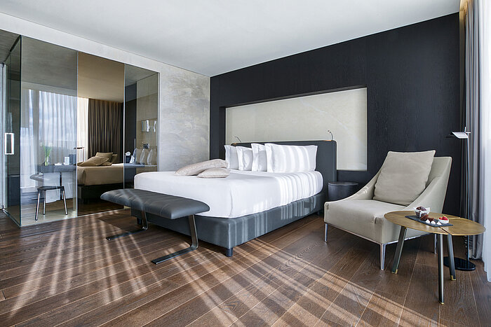 Modern hotel room at Maritim Hotel Plaza Tirana with glass partition, designer furniture and wooden floor