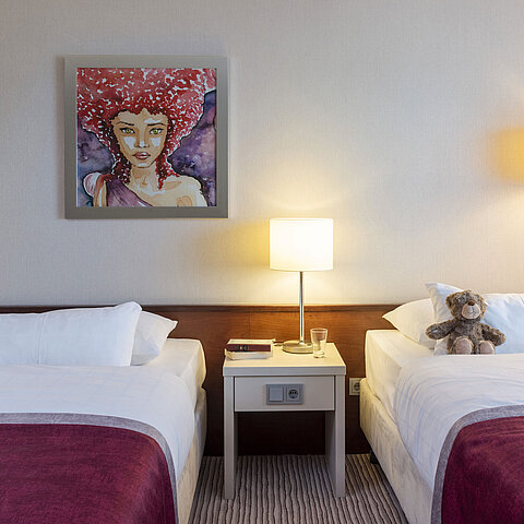 Classic family room at Maritim Hotel Bonn with two beds, bedside table, and modern art for a comfortable stay.