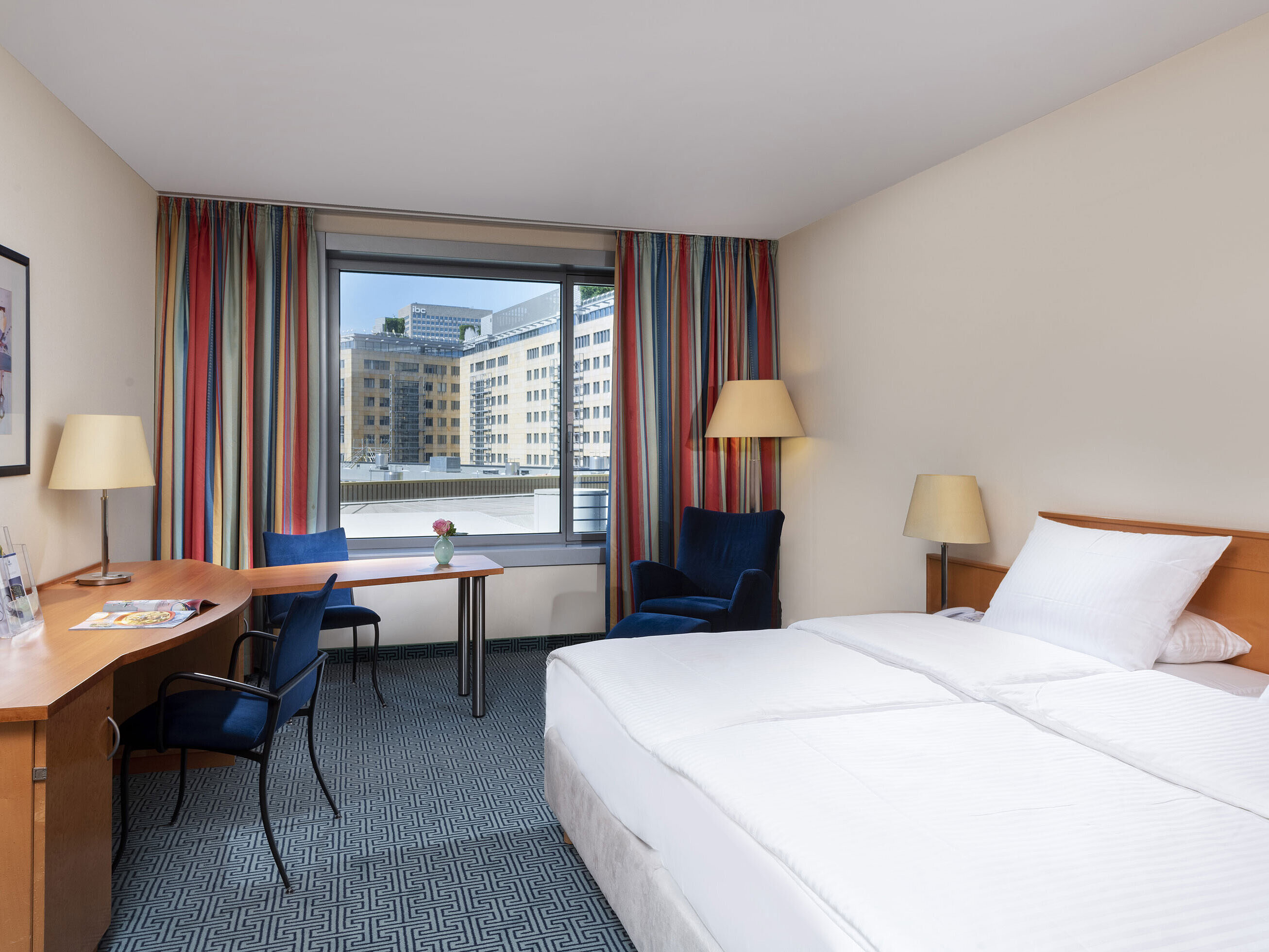Classic room at Maritim Hotel Frankfurt with a cozy double bed, desk, and city view.