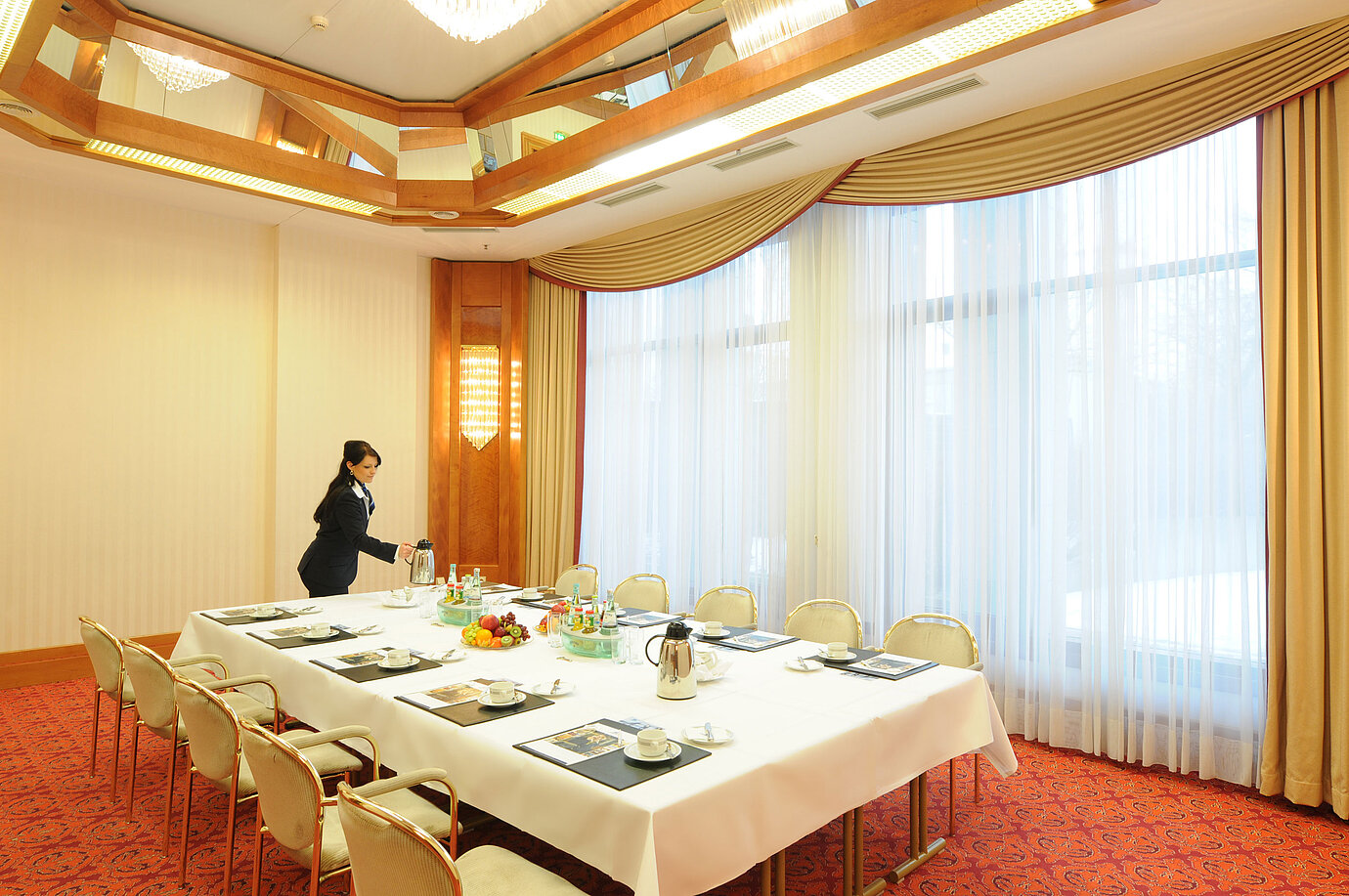 Elegant meeting room with natural light, set table, and warm ambiance at Maritim Hotel Magdeburg.