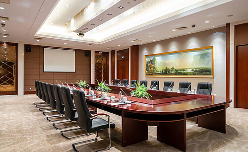 配備大型會議桌、黑色皮革座椅、投影幕及頂級照明系統的現代化會議室