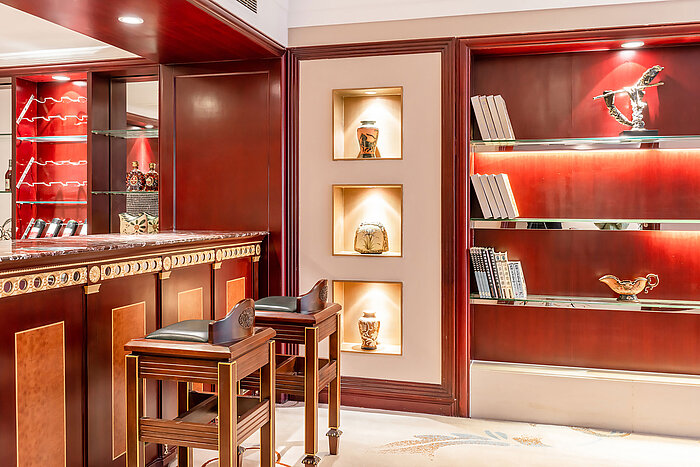 典雅經典的酒吧區，配備木質吧檯、高腳凳、發光層架、裝飾擺件及時尚的書籍展示區