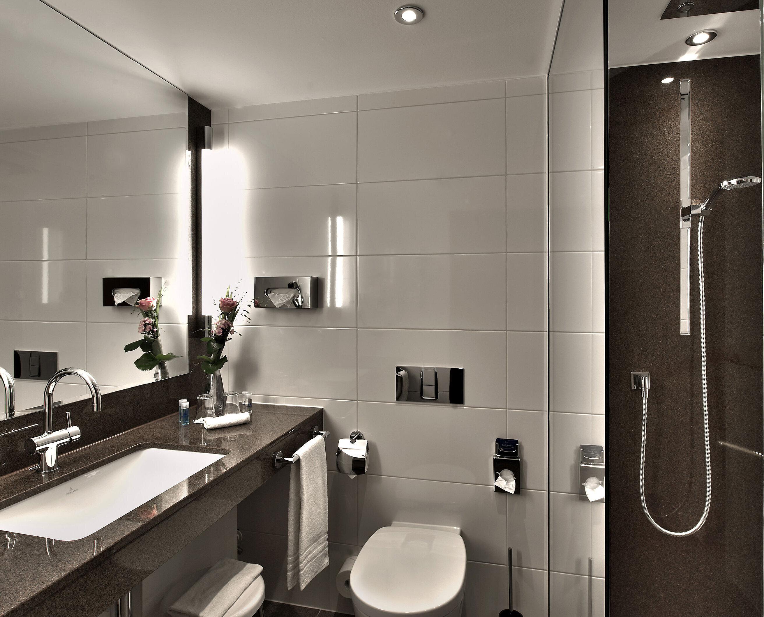 Modern bathroom at Maritim Hotel Cologne with bathtub, large mirror, and stylish lighting in neutral tones.