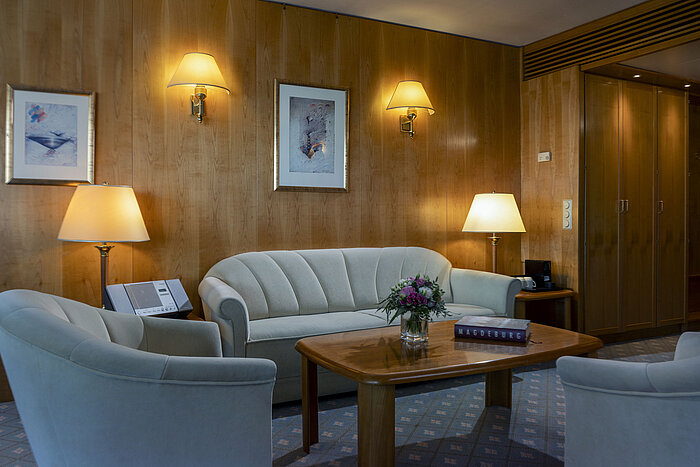 Cozy seating area in a suite at the Maritim Hotel Magdeburg with elegant furnishings and a warm ambiance.