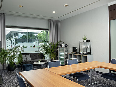 Salon Kiel with sofa, plants and large windows at the Maritim Hotel Darmstadt