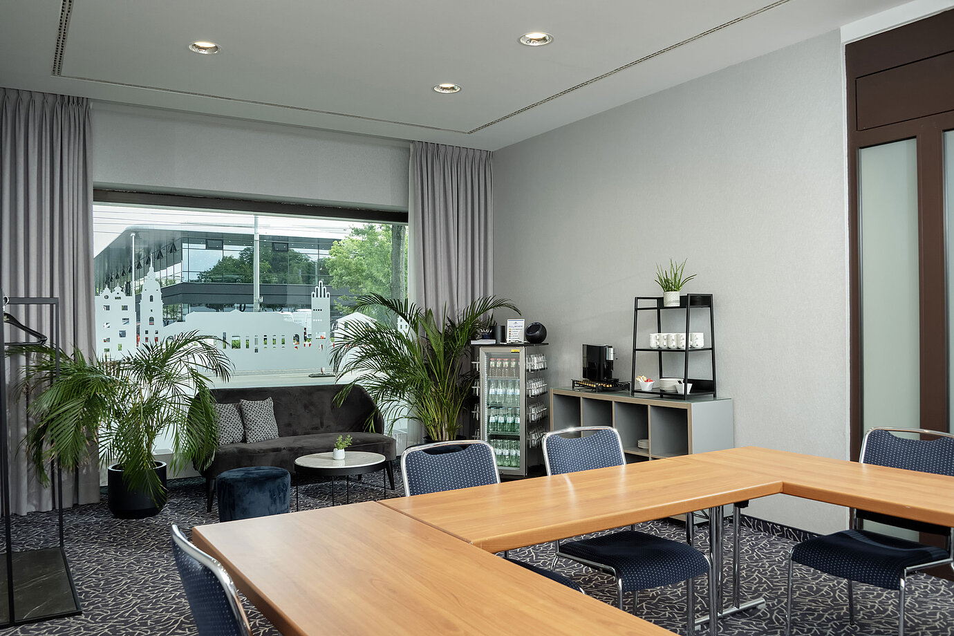 Salon Kiel with sofa, plants and large windows at the Maritim Hotel Darmstadt