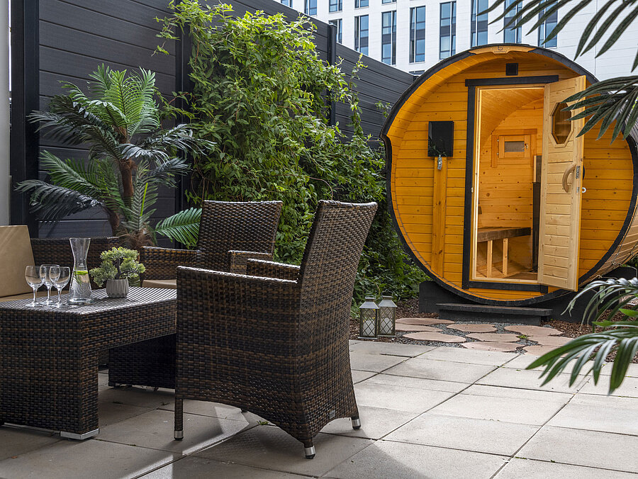 Cosy outdoor area with seating and barrel sauna at Maritim Hotel Travemünde